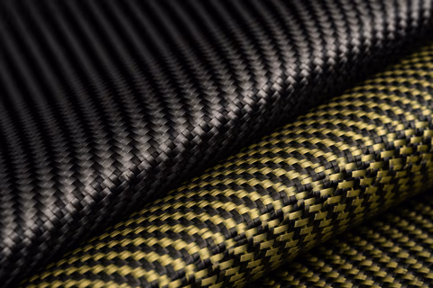 Carbongewebe in Schwarz neben Carbon-Kevlar-Gewebe mit gelben Aramidfasern